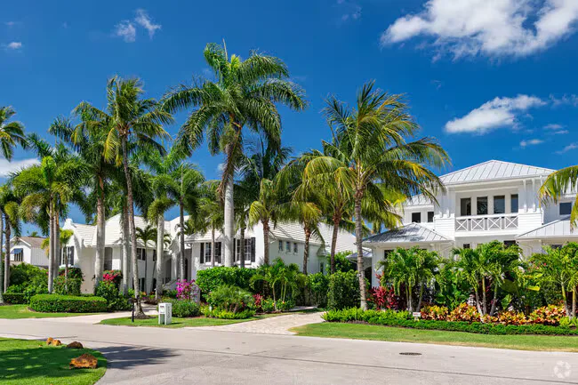 Luxury coastal facade in Aqualane Shores with Caribbean-Colonial white stucco and tropical gardens