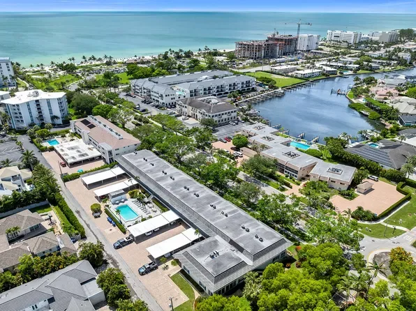 Aerial view of coastal property complex in Coquina Sands with residential buildings, pools and lagoon