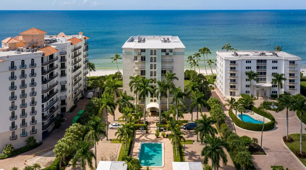 Aerial view of beachfront condominium complex in Coquina Sands with tropical landscaping and direct Gulf access