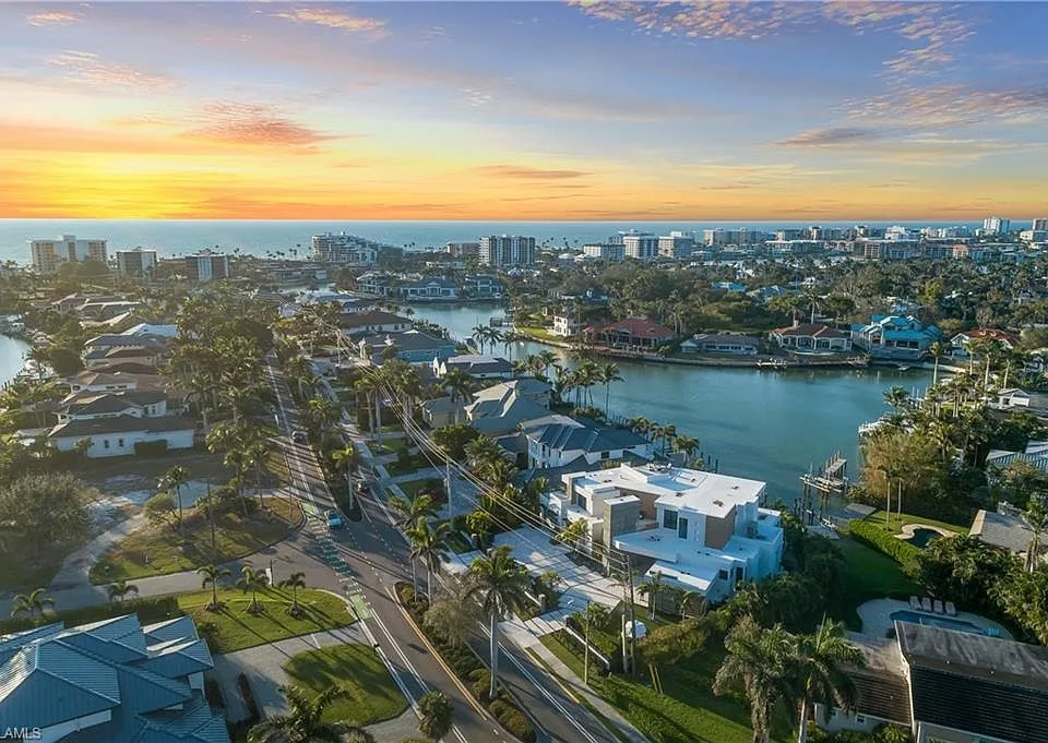 Waterfront canal homes and palms near Park Shore at sunset