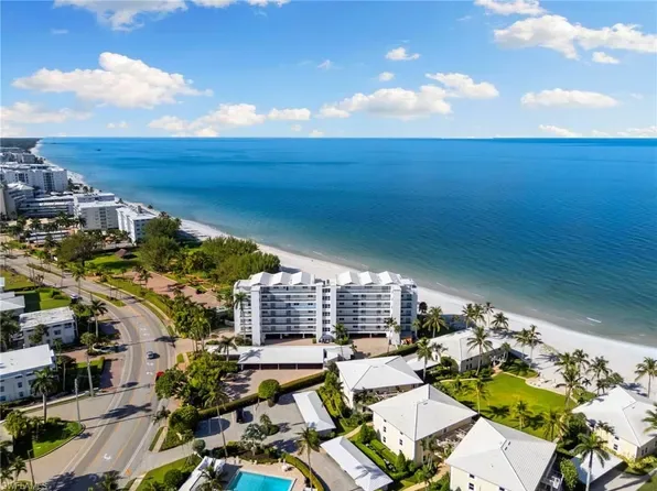 Mid-rise white condominium surrounded by tropical landscaping near the Park Shore beach