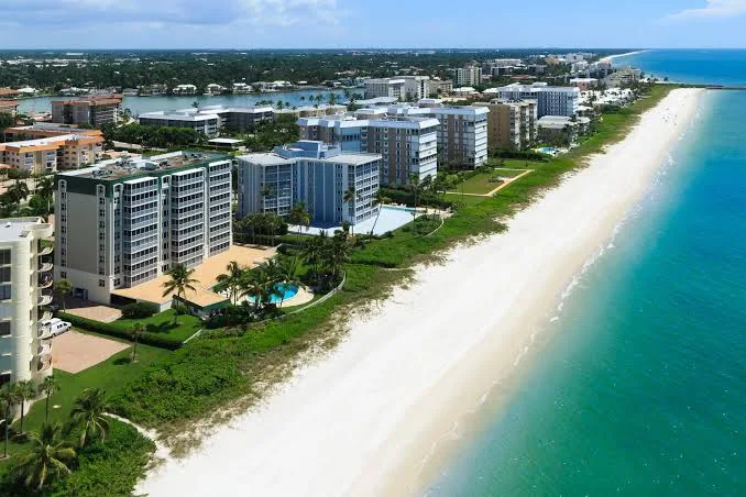 High-rise residences along the Park Shore coastline with white sand beach and turquoise Gulf water