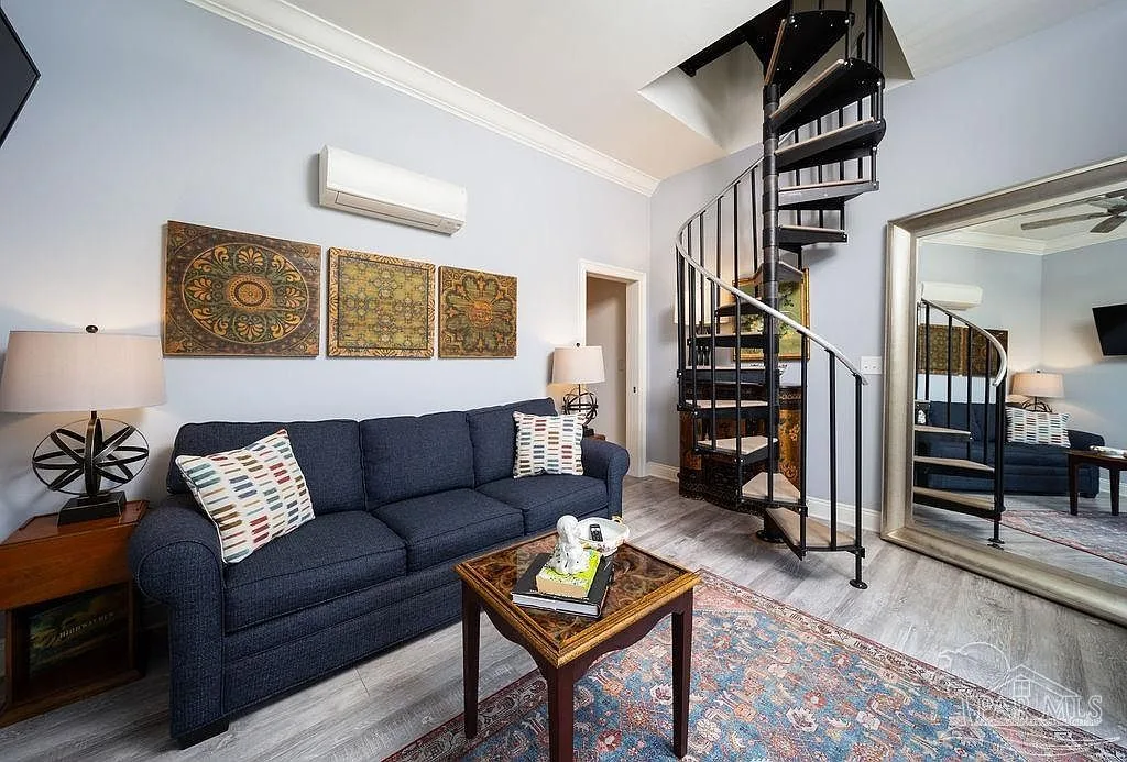A spiral staircase rising through a light-filled living space in the tower.