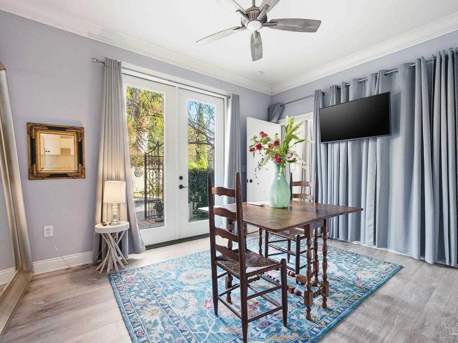 The dining and seating area with French doors opening toward the pool courtyard.