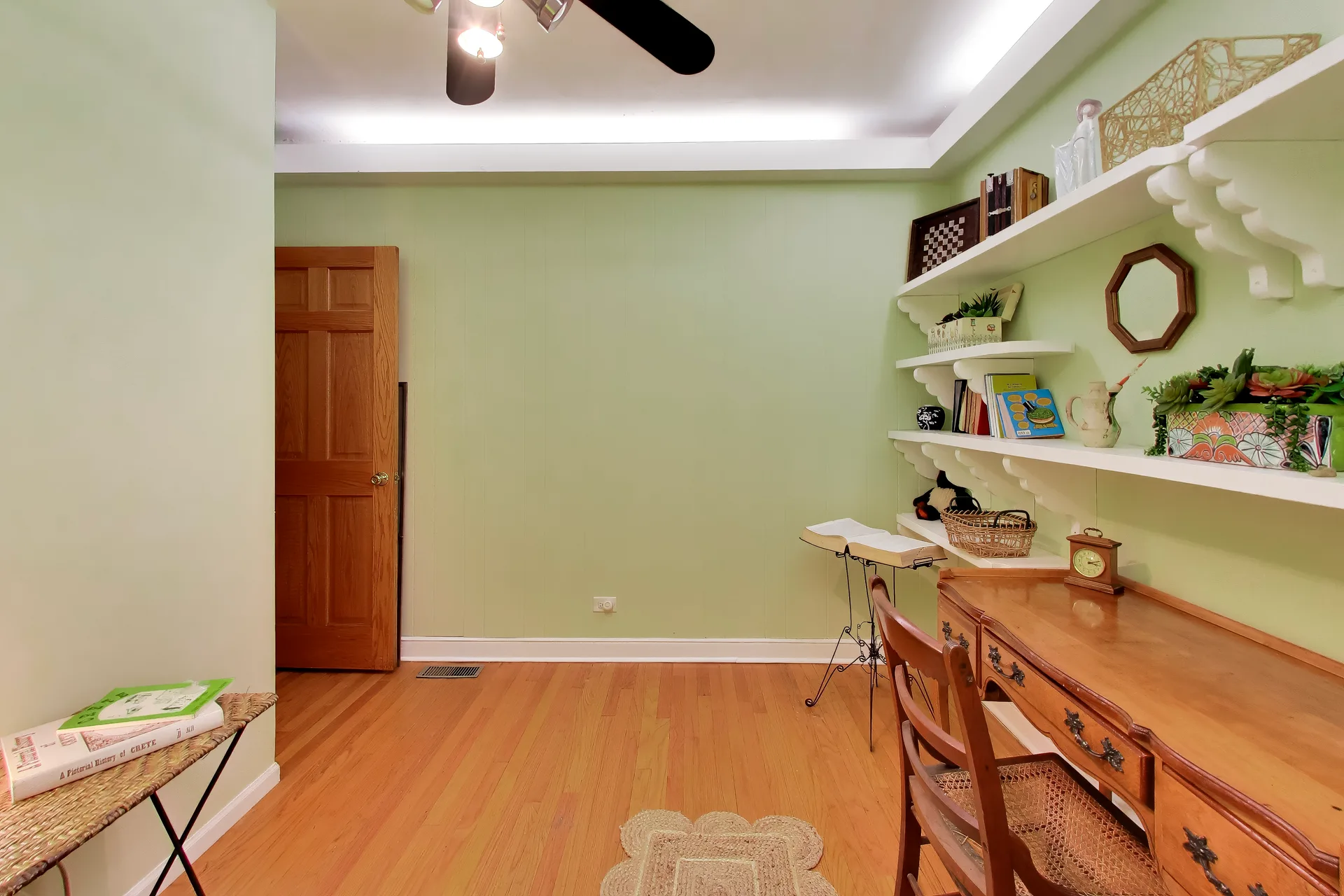 Home office with green walls and hardwood floors