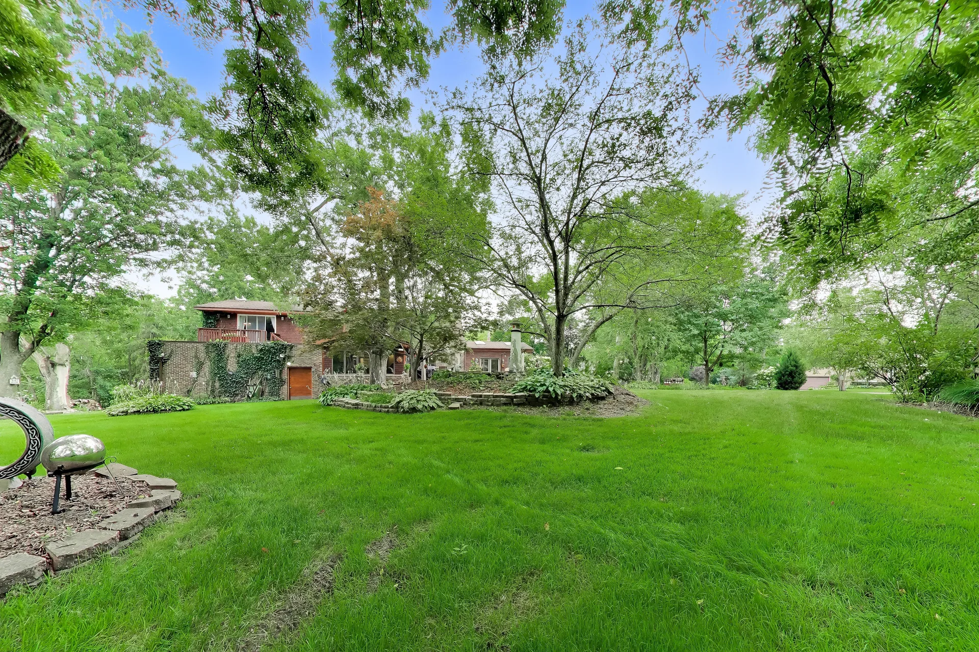 Wide view of the landscaped backyard with stone retaining walls