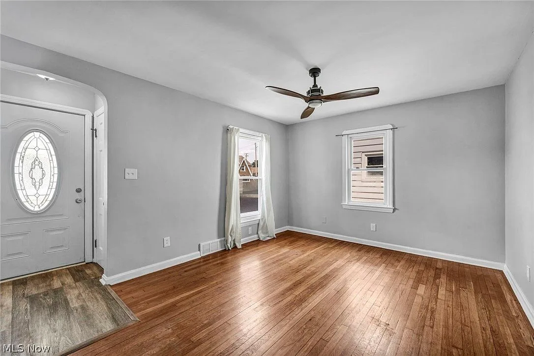 Living room entrance with an arched doorway and polished hardwood floors