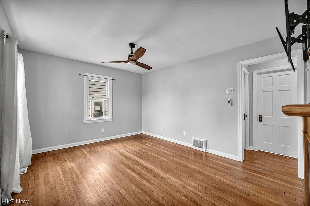 Wide-angle living room view with hardwood floors and bright natural light