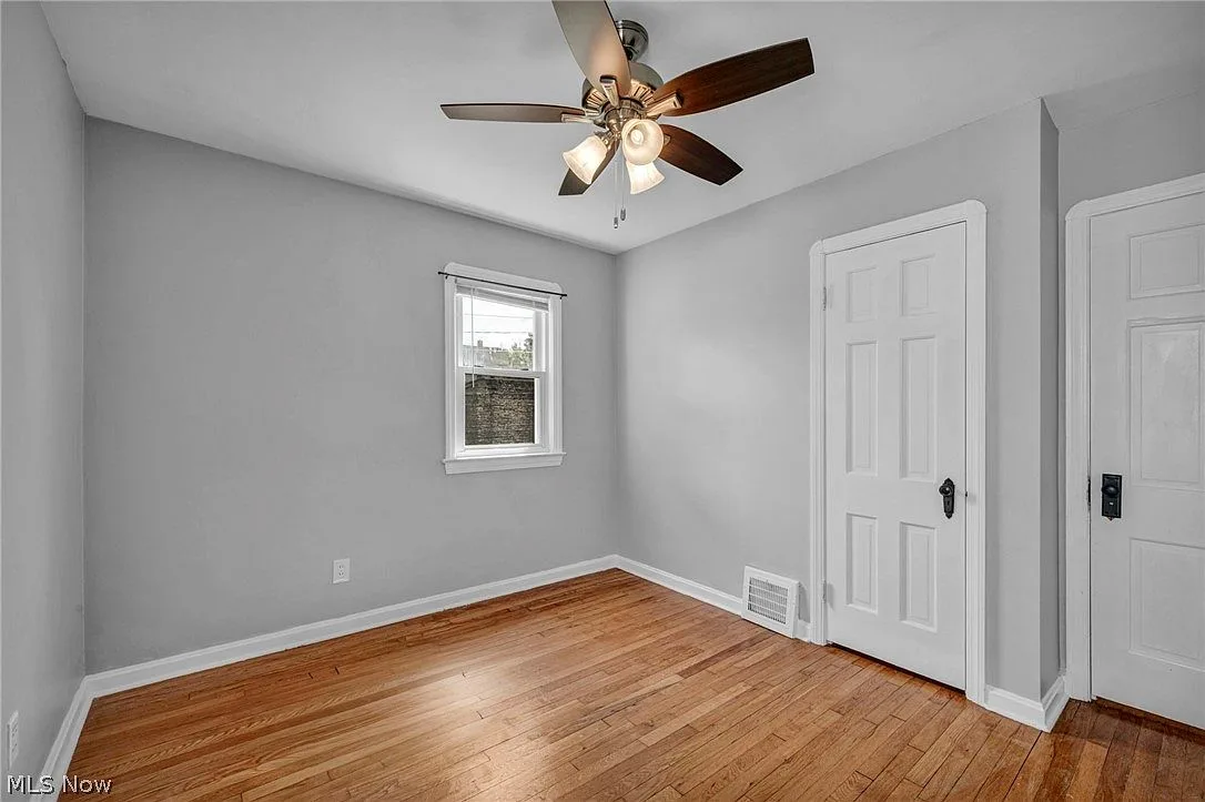 Second bedroom view with hardwood flooring and natural daylight