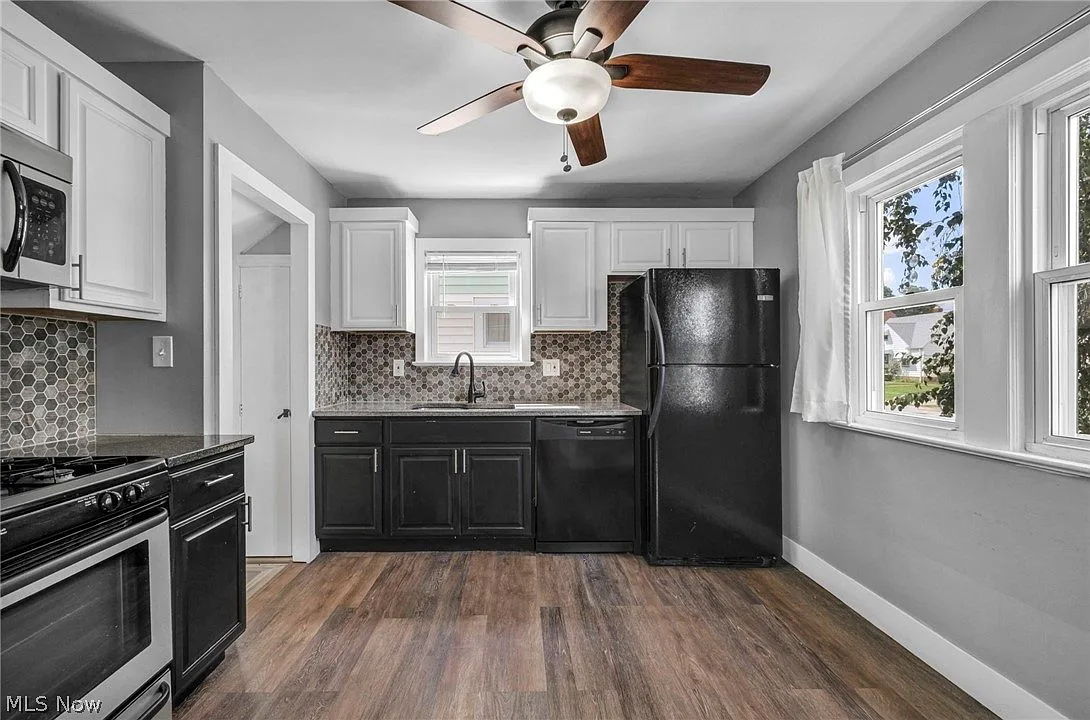 Updated kitchen with granite countertops, hex tile backsplash, and two-tone cabinetry