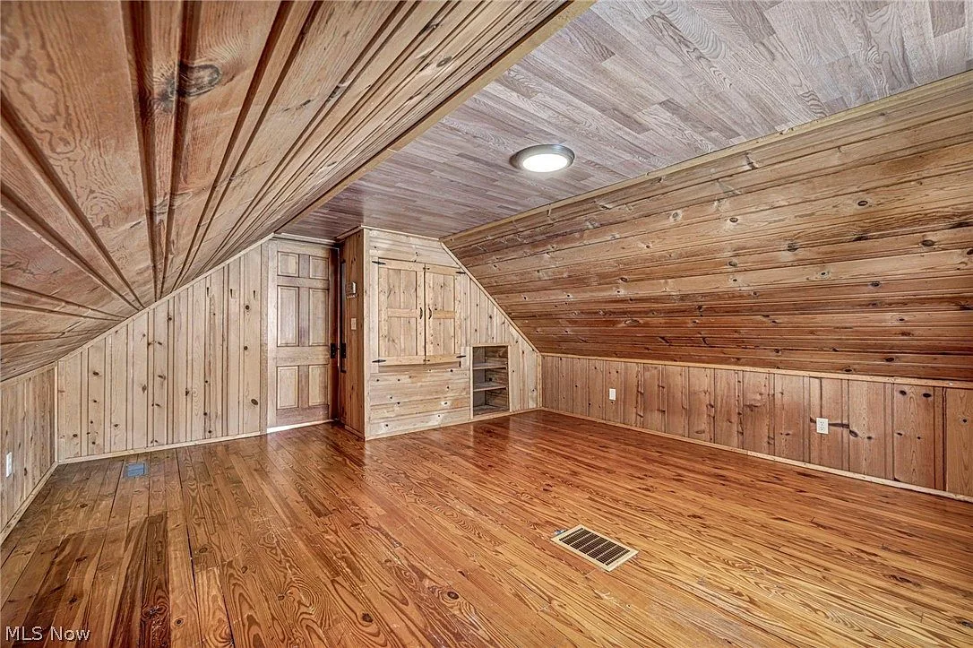 Upstairs primary bedroom with warm wood paneling and built-in storage