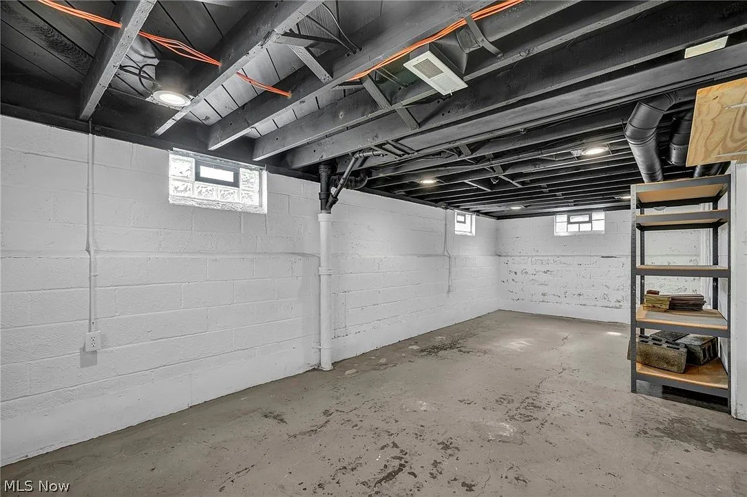 Finished basement storage with white block walls and exposed ceiling joists