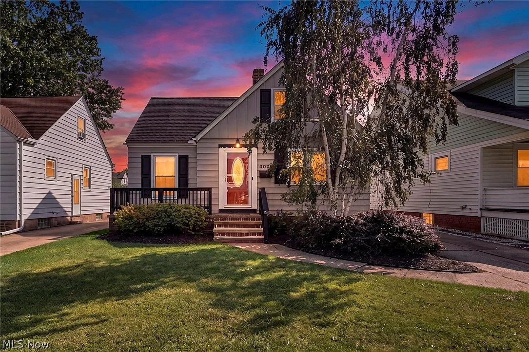Front facade at sunset with a mature birch tree and landscaped garden beds