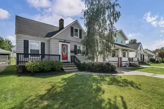 Street view of the 3021 Tuxedo Ave bungalow with its front yard and driveway in Parma, Ohio