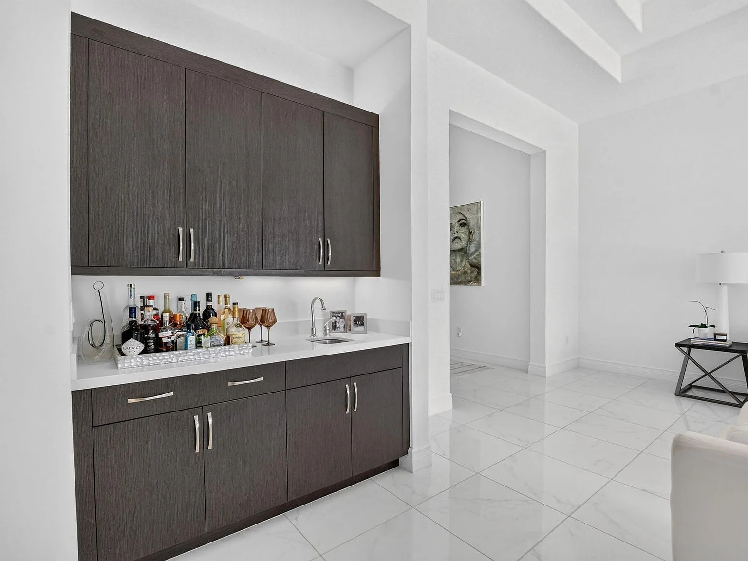 The built-in wet bar at 16740 Strasbourg Lane with dark wood cabinetry and a quartz countertop