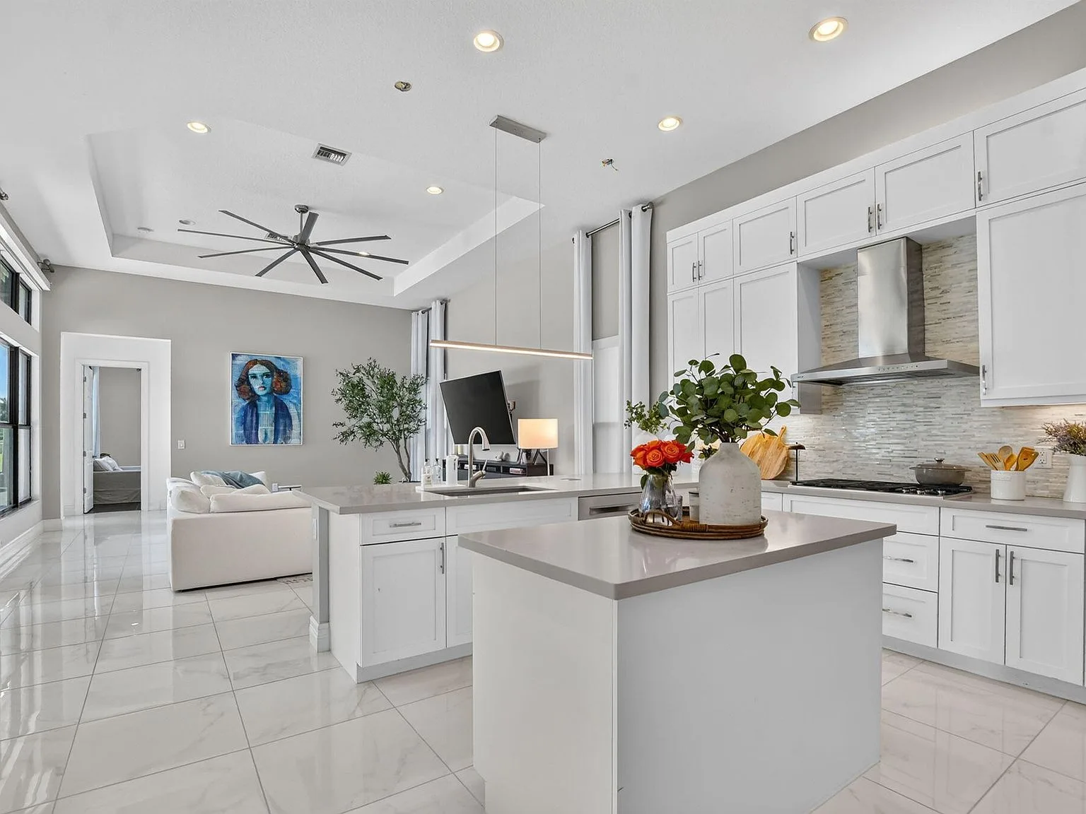 The open-concept kitchen at 16740 Strasbourg Lane opening to the living area, with white cabinetry and quartz counters