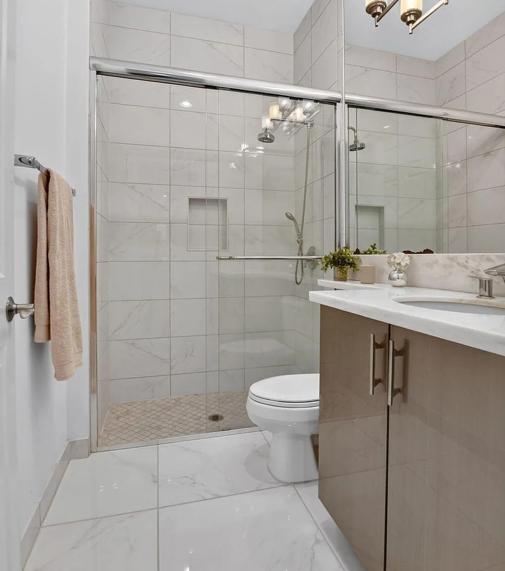 A bathroom at 16740 Strasbourg Lane with a taupe vanity and large-format marble-look wall tile