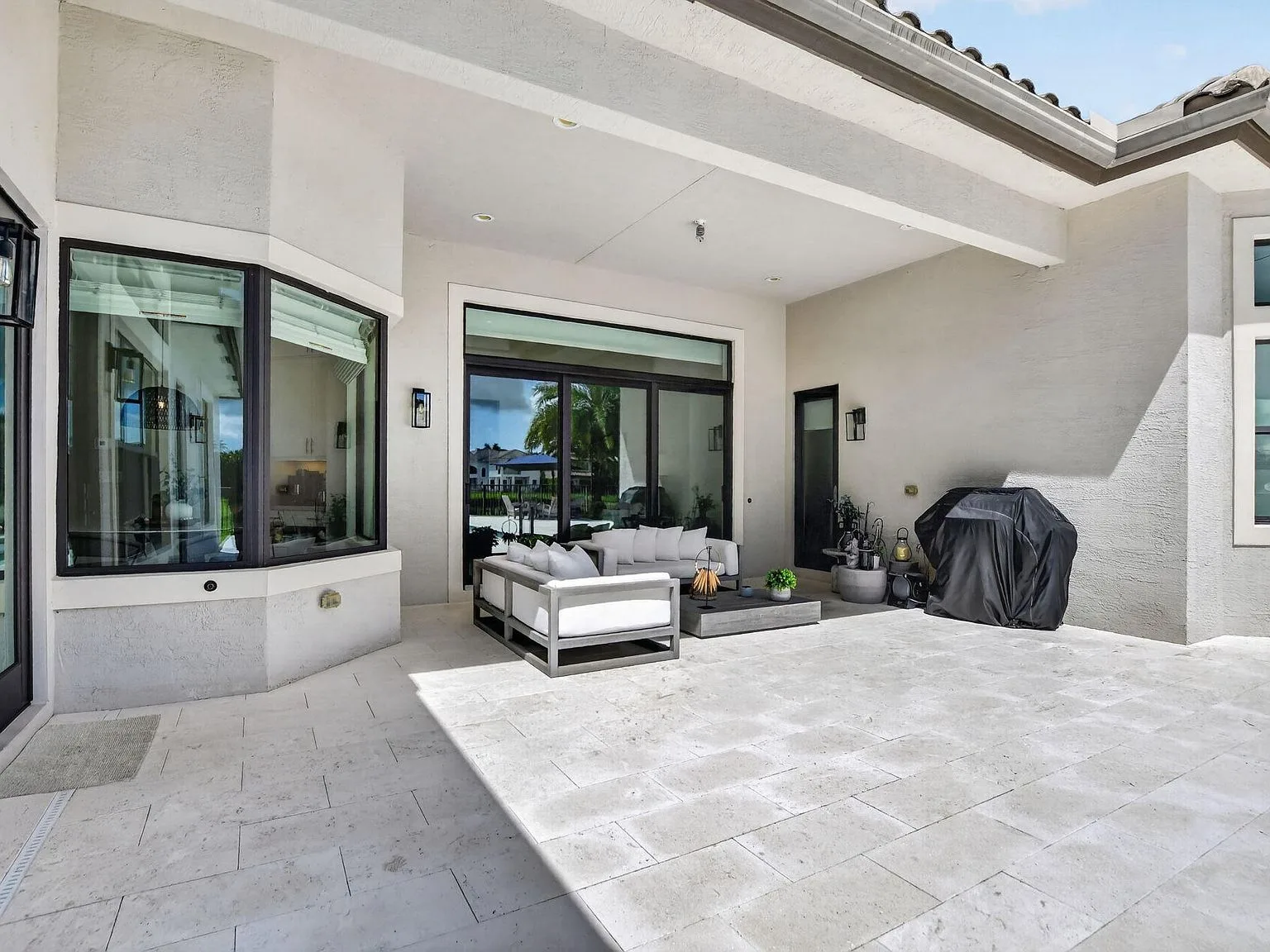 The covered lanai at 16740 Strasbourg Lane with large impact sliding glass doors opening to the backyard