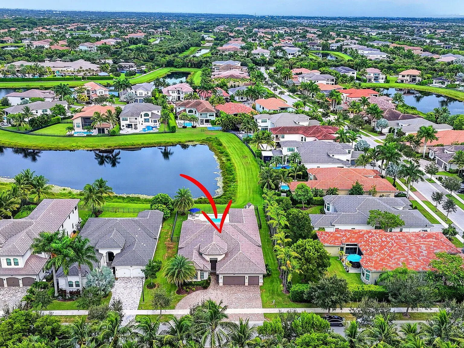 Drone aerial view of the lakefront home and pool at 16740 Strasbourg Lane in Seven Bridges