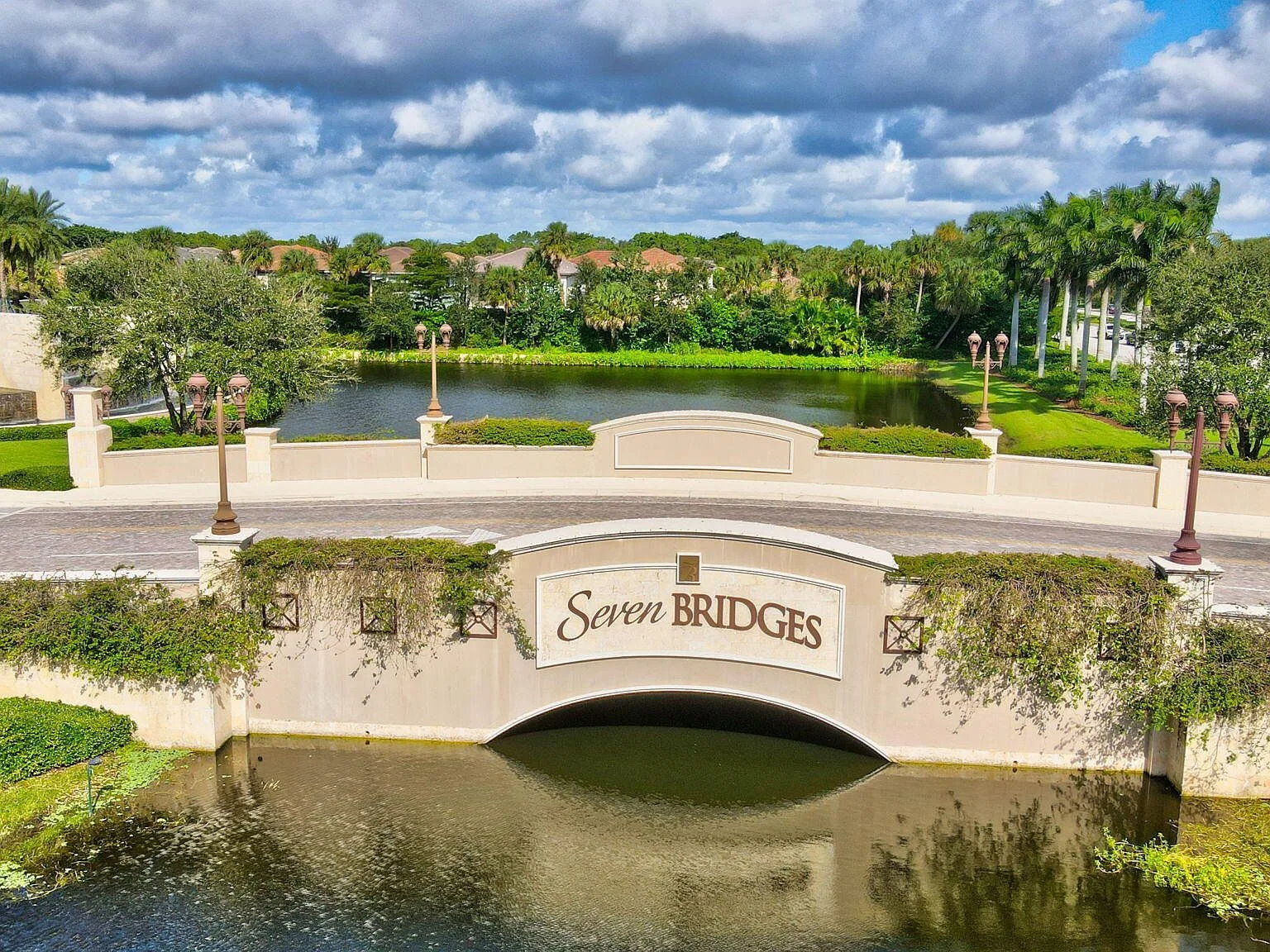 The Seven Bridges community entrance bridge with its signature signage and iron lamps in Delray Beach
