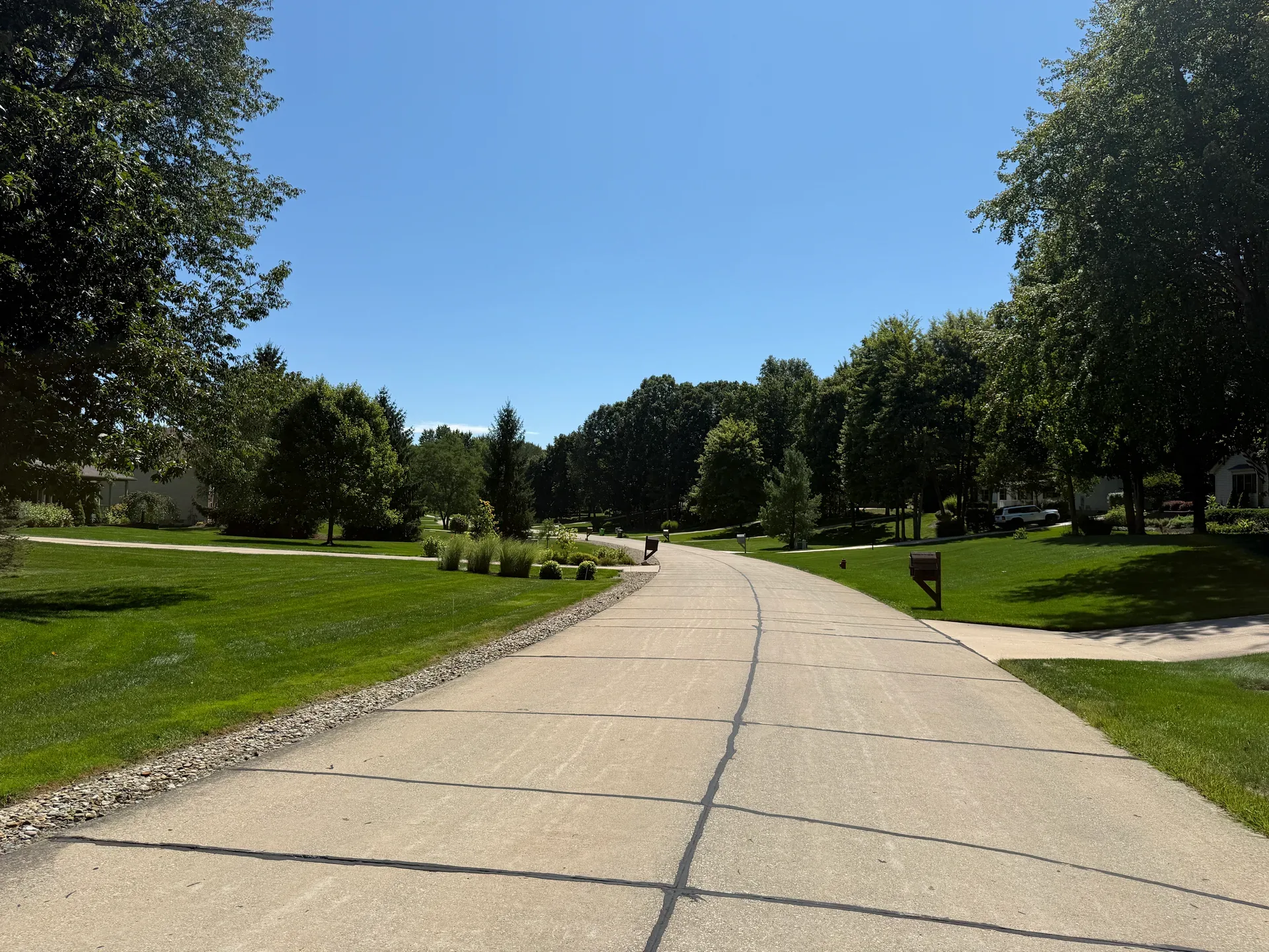 Tree-lined suburban residential street in Barn Run with concrete curbing and green lawns
