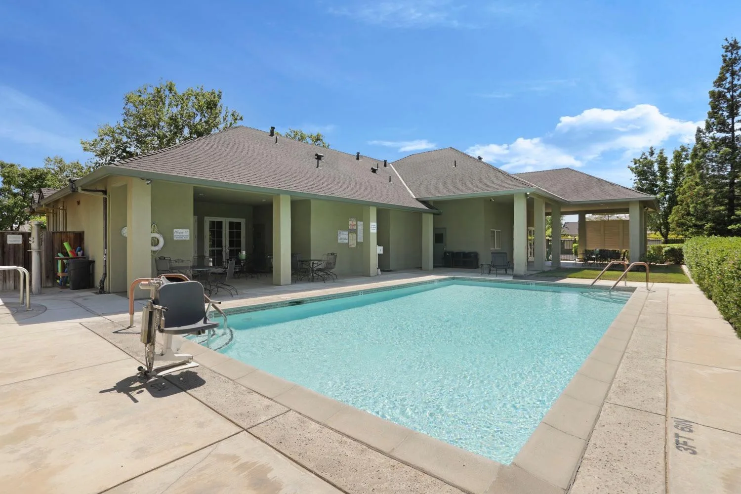 A community pool and covered patio in a South Sacramento 55+ neighborhood on a sunny afternoon