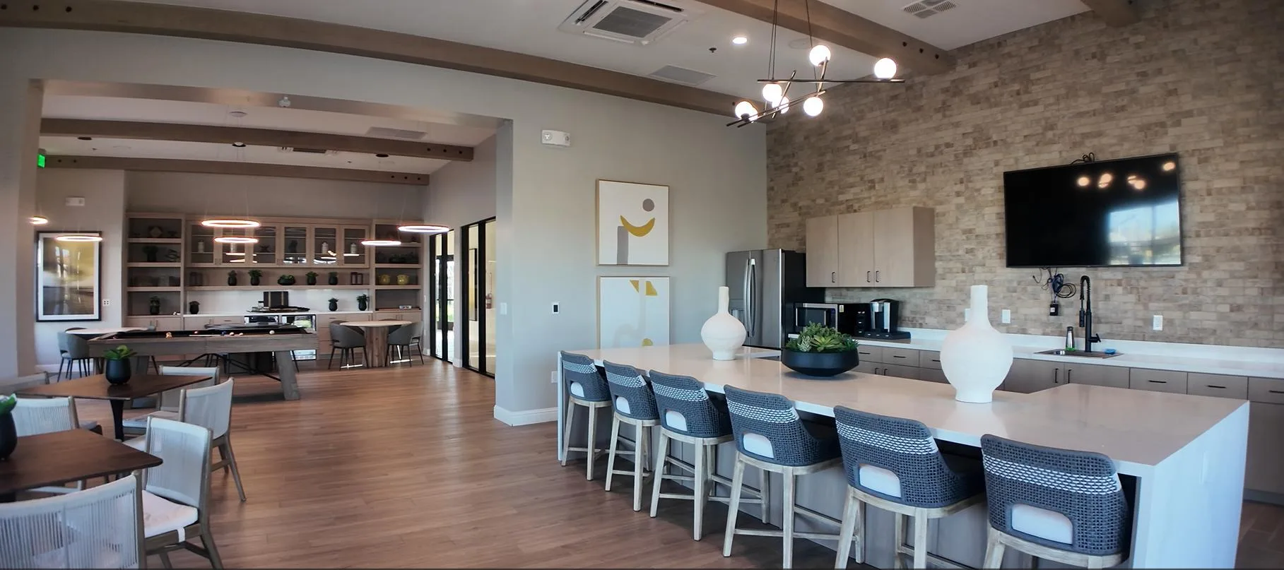 A modern kitchen with a large island and lounge seating in a single-story community home