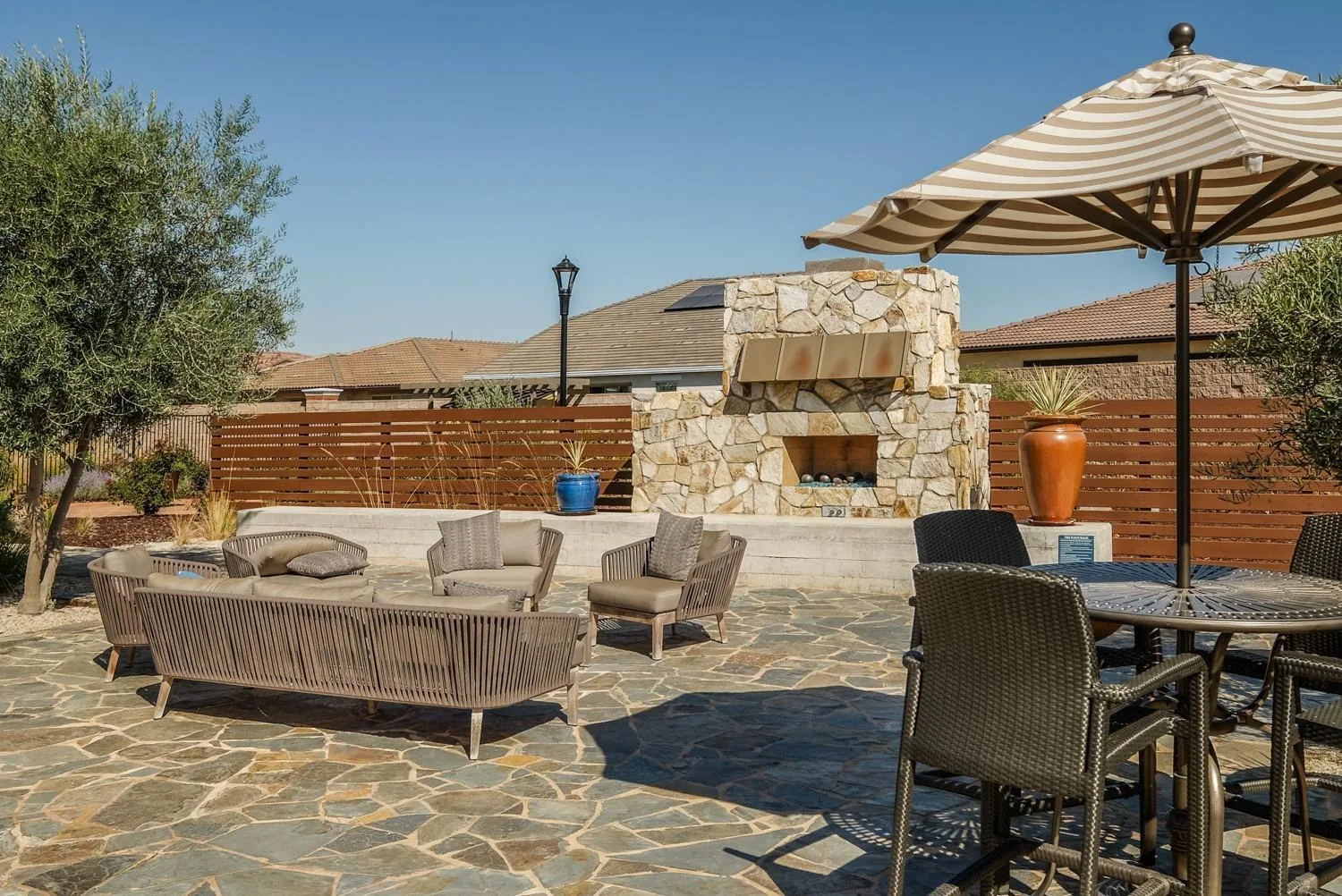 A stone patio with an outdoor fireplace at a home in Heritage El Dorado Hills, El Dorado Hills, California