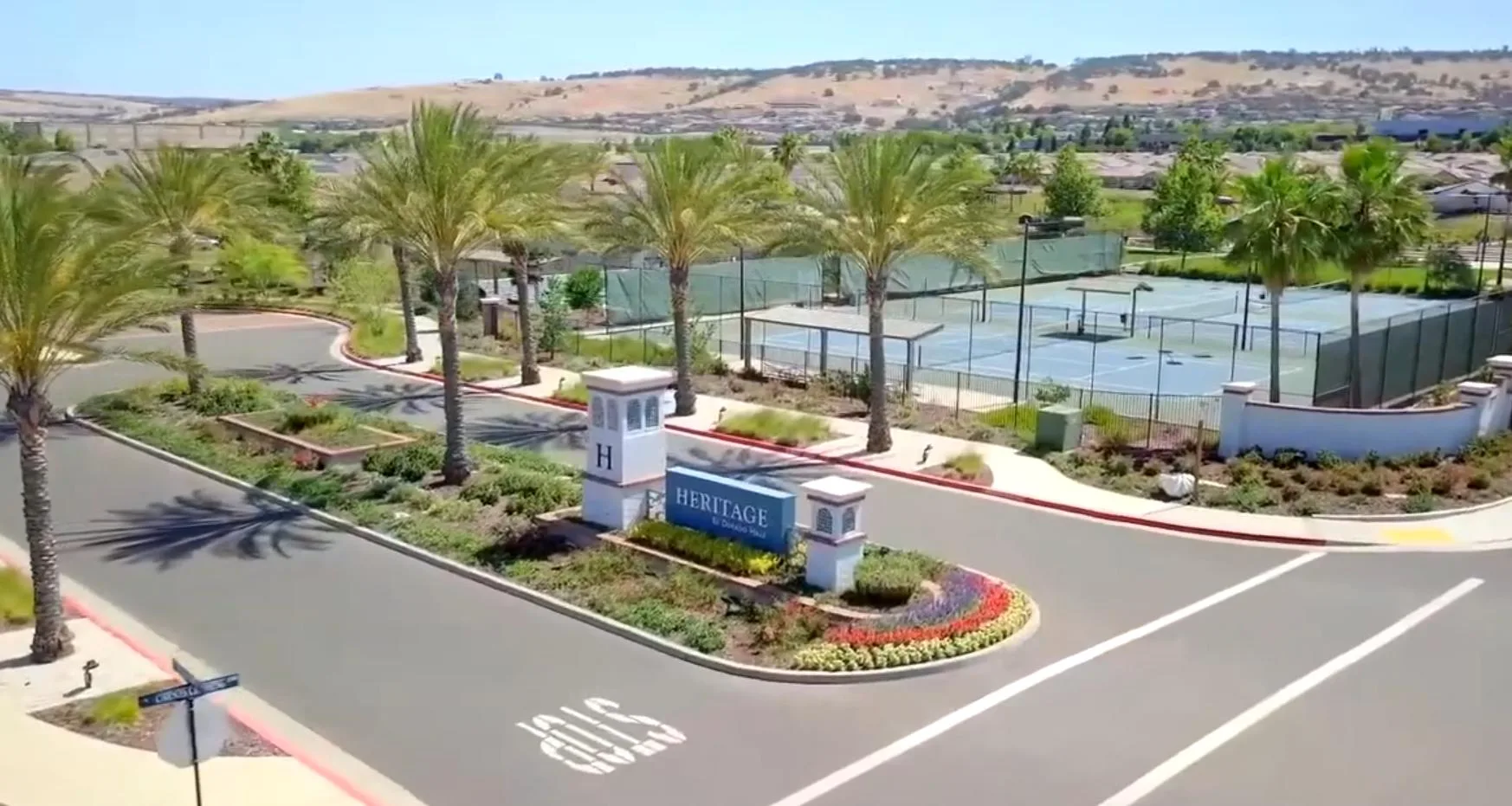 Aerial view of a Heritage community entrance in Roseville with landscaping and courts beyond.