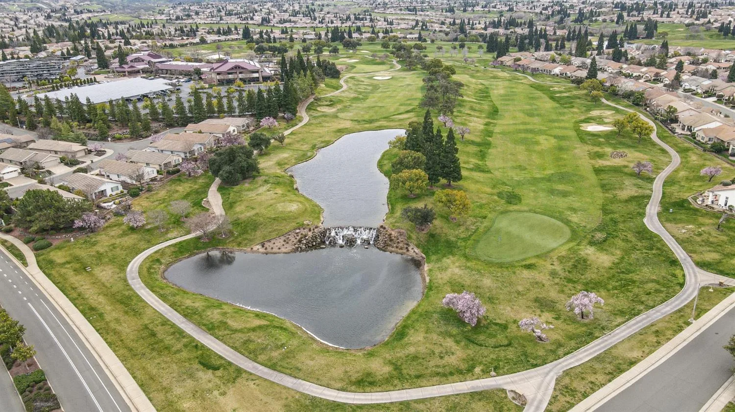 Aerial view of a golf course with a pond and small waterfall at Sun City Lincoln Hills, the Del Webb 55+ community in Lincoln, California