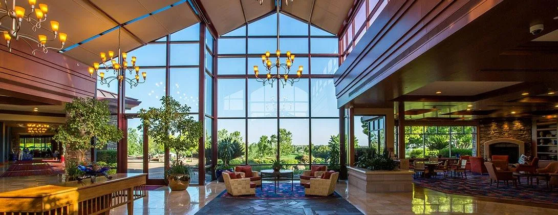 The grand lobby of the Orchard Creek Lodge at Sun City Lincoln Hills, with stone walls and tall windows