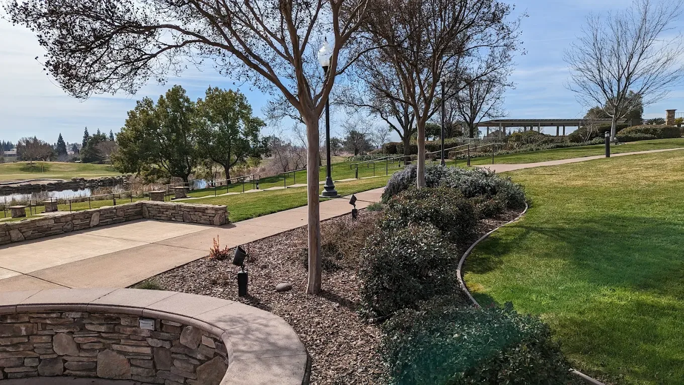 A paved pathway through a landscaped common area in a Northern California 55+ community;the healthcare-access buyer guide maps the medical systems near each 55+ community corridor.