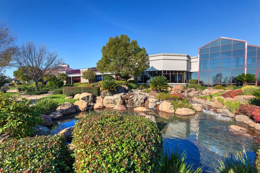 A modern community clubhouse with a landscaped pond in a Northern California 55+ community.