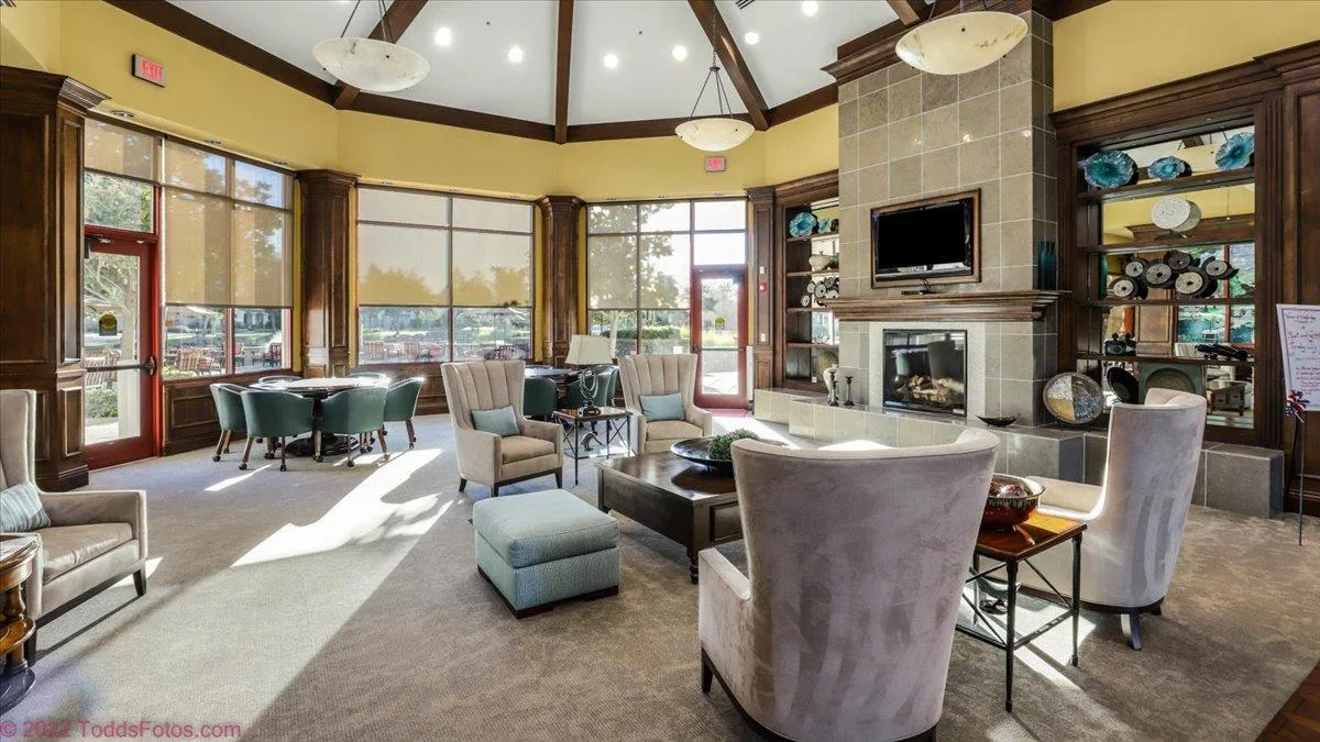Warmly lit community lounge with a fireplace and comfortable seating in a 55+ community clubhouse.