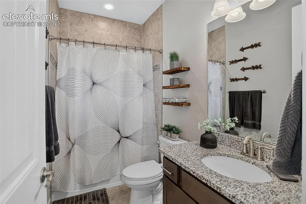 Guest bathroom with granite vanity and tile shower surround