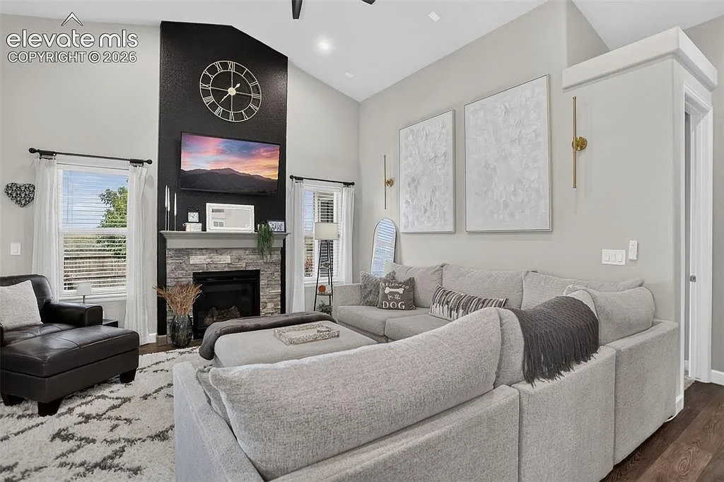 Living room with vaulted ceiling and stone faced fireplace