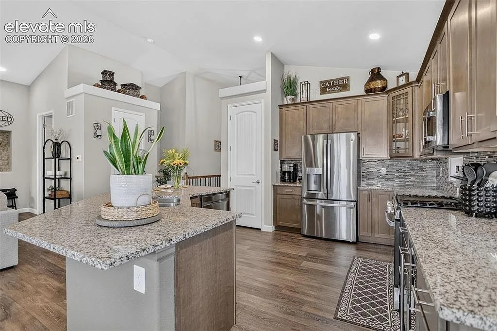Modern kitchen with granite countertops, wood cabinetry and stainless steel appliances at 10988 Tarbell Dr