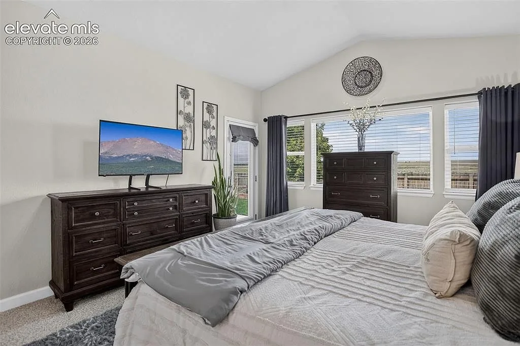 Primary bedroom on the main level with vaulted ceilings at 10988 Tarbell Dr