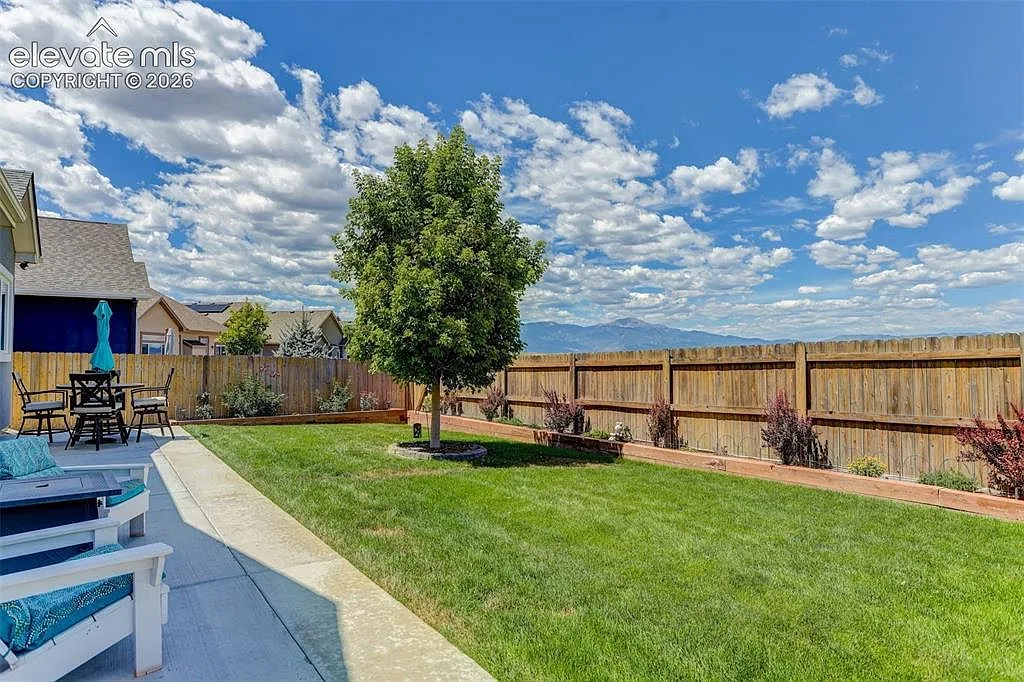Backyard of 10988 Tarbell Dr with patio, lawn and mountain views