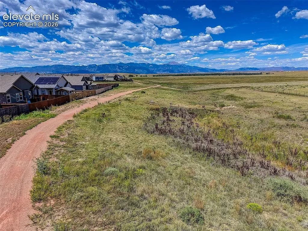 Drone view of open space and walking trails beside homes in Lorson Ranch