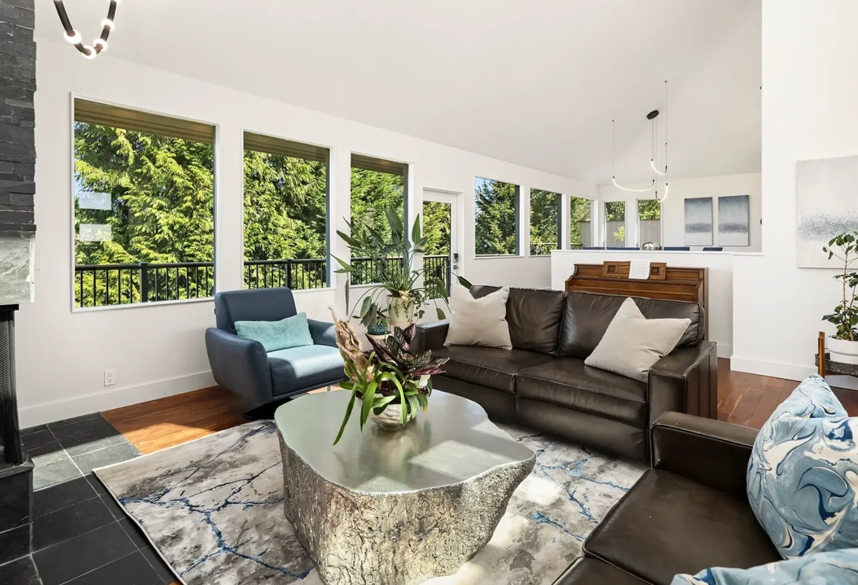 Bright living room with high ceilings, large windows, and walls of glass filling the space with natural light