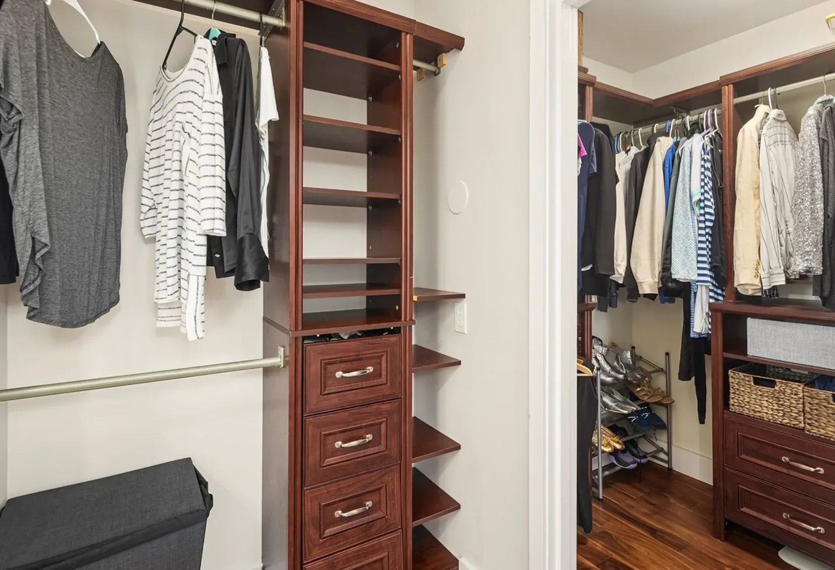 Walk-in closet tucked behind the primary bedroom with shelving and hanging space