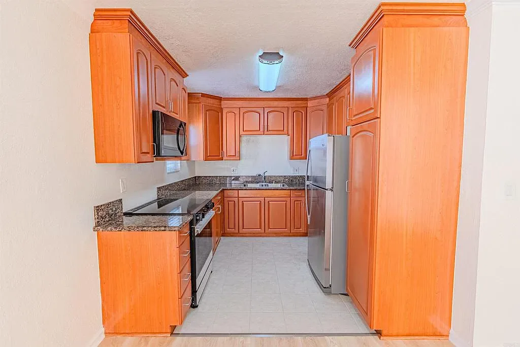 Galley kitchen with granite counters at 1085 12th St Unit F