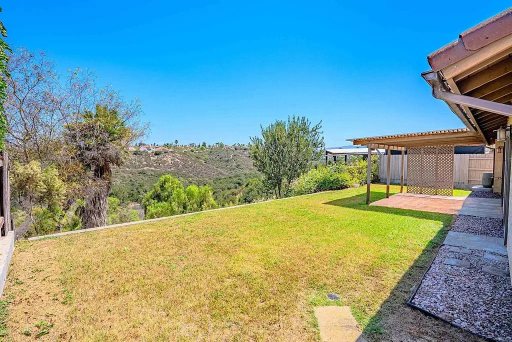 Backyard hillside view with lawn and patio at 637 Redlands Pl