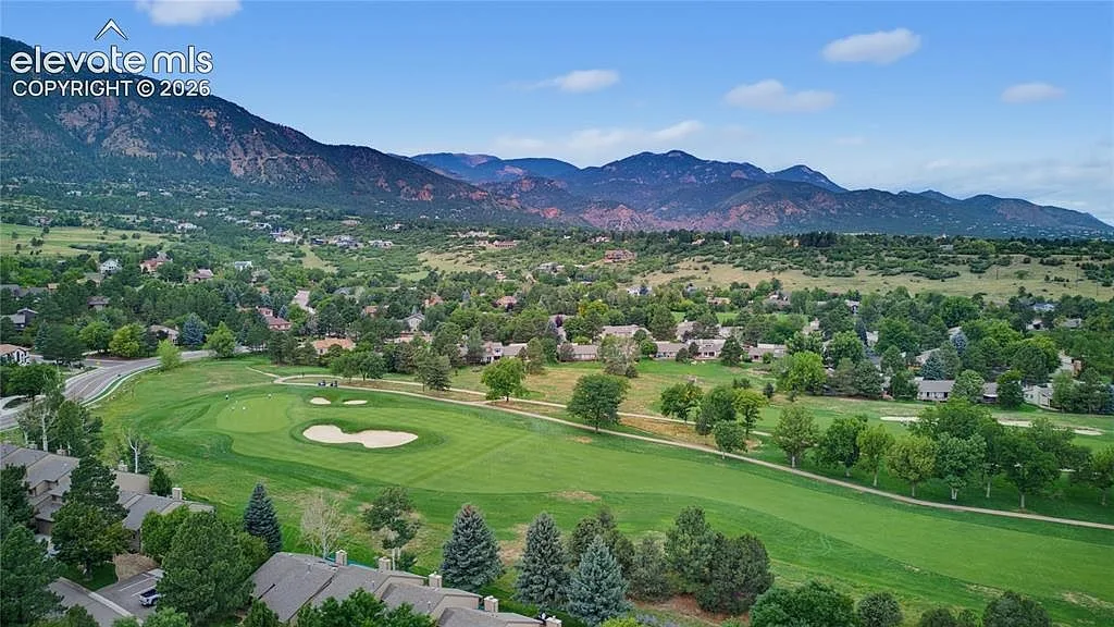 Aerial of the community and golf course with the Cheyenne Mountains behind