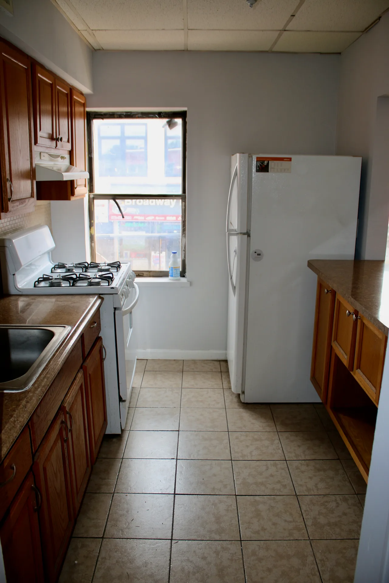 Renovated 59 Broadway kitchen with wood cabinets and stainless steel appliances