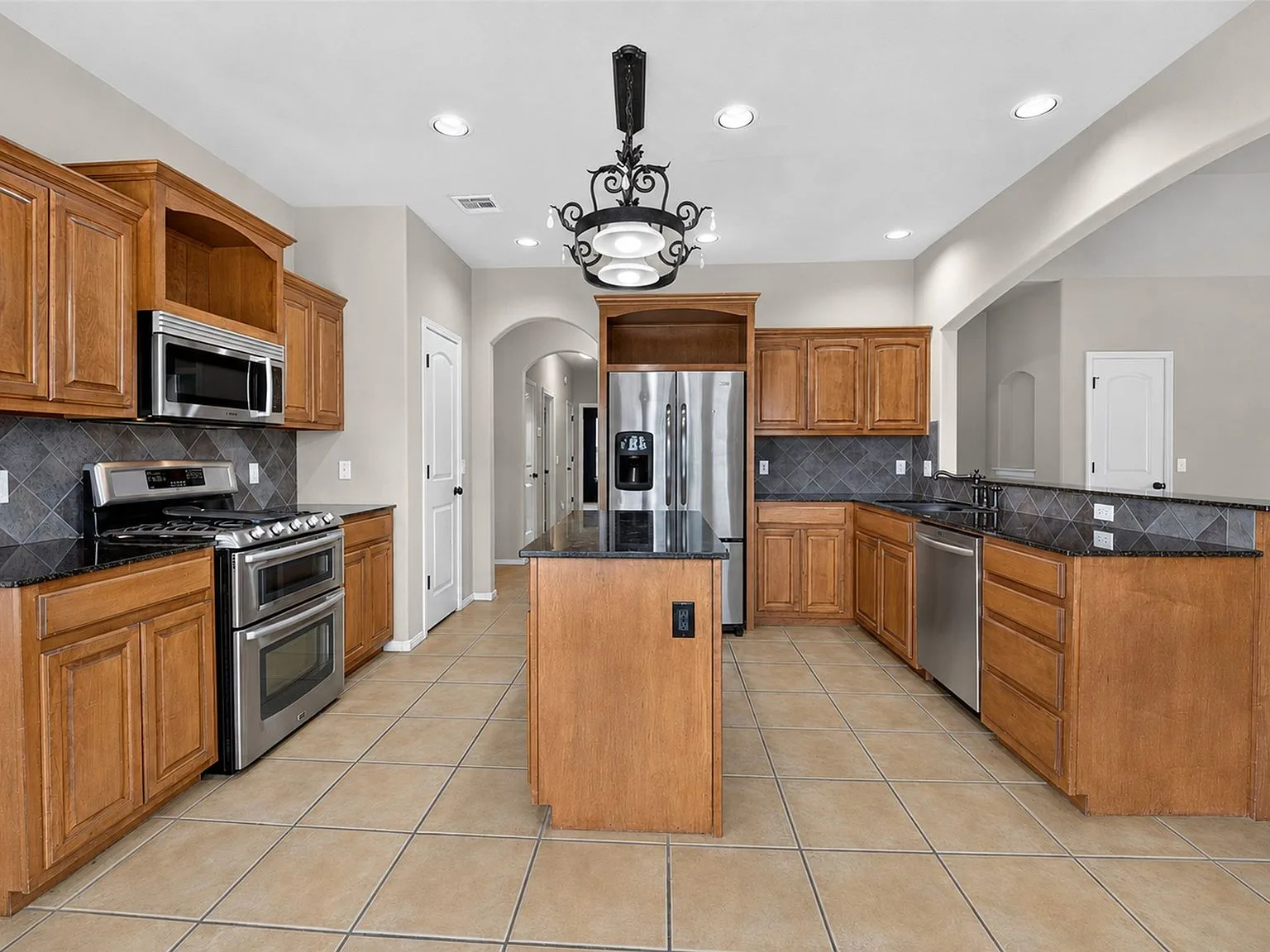 Kitchen at 4604 N Narcissus Ave with granite counters, double ovens, and stainless appliances