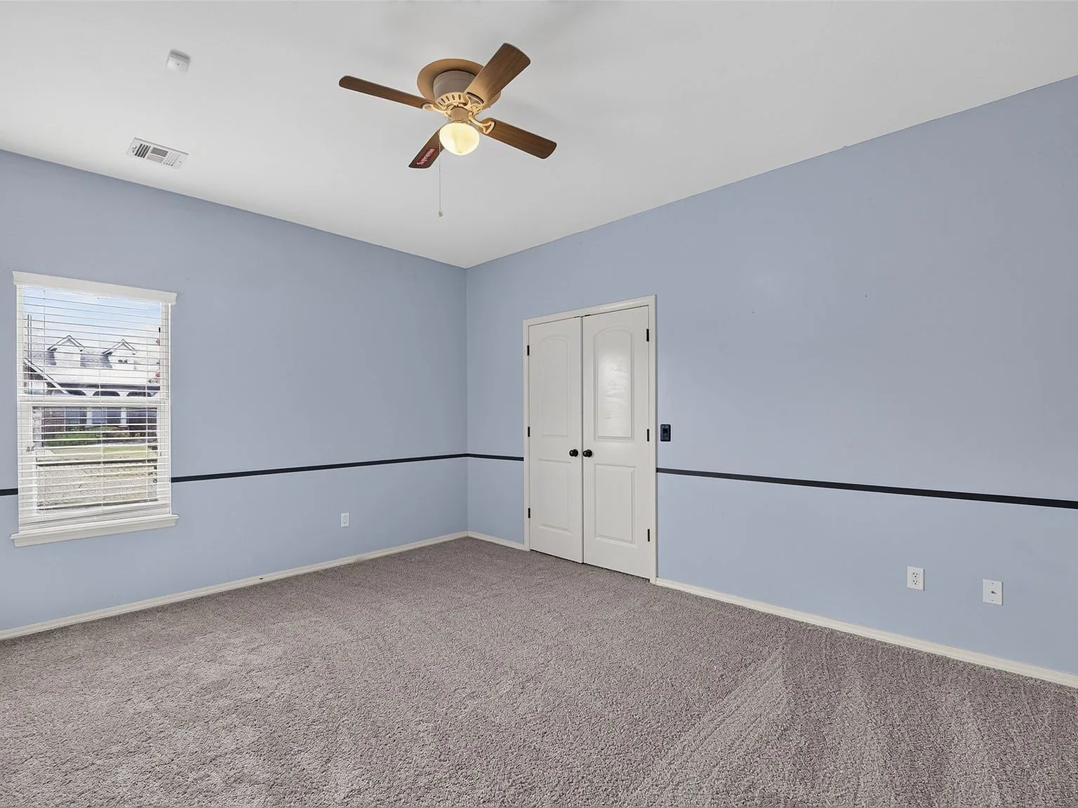 Bedroom with chair rail and light blue walls