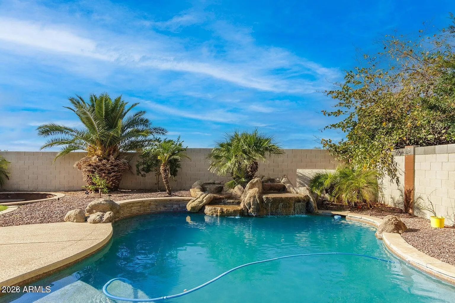 Private fenced play pool with desert landscaping at 9124 W Elm Street