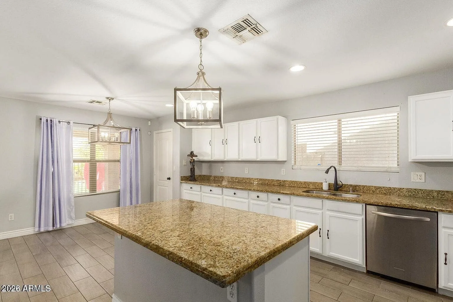 Bright white kitchen with granite countertops and a center island